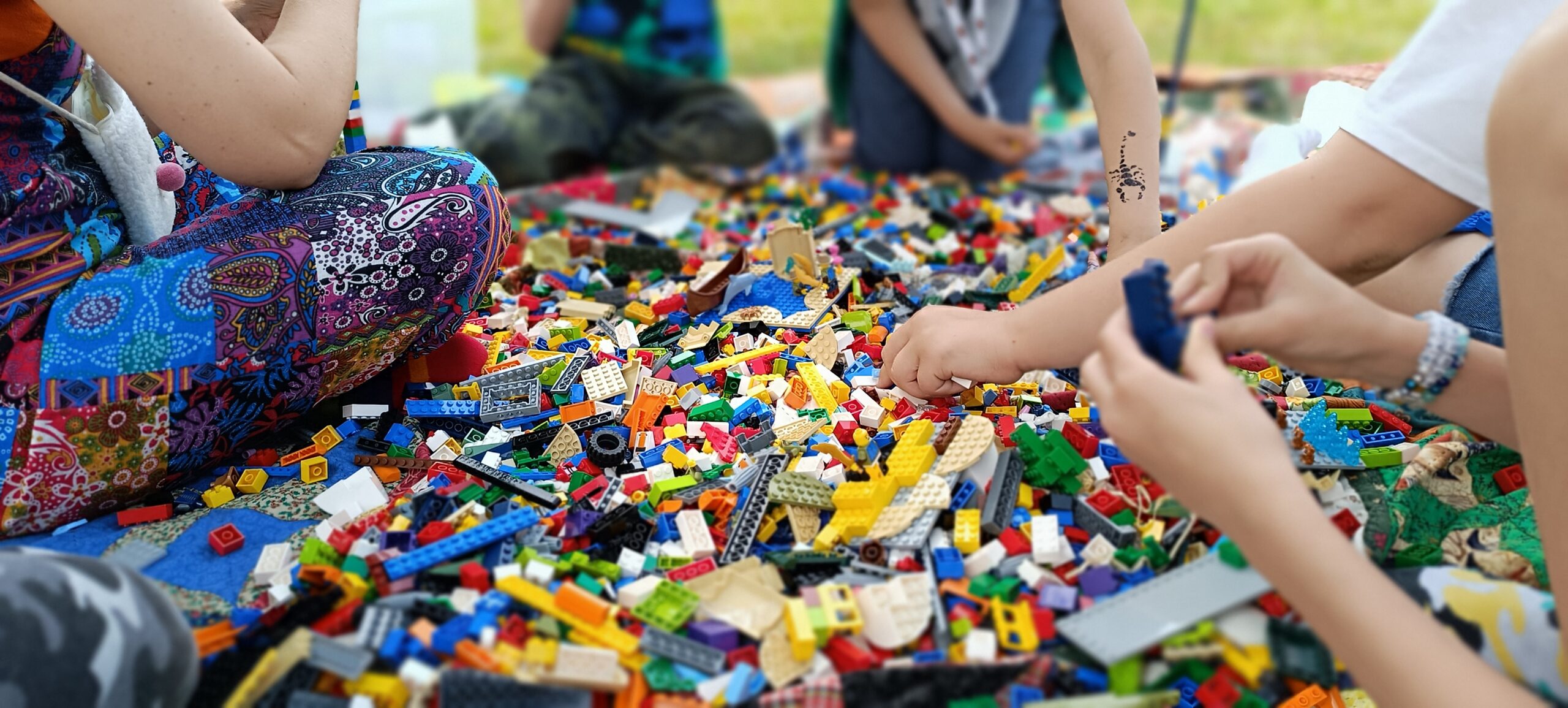 Klocki lego rozsypane na kocu na podwórku podczas festynu