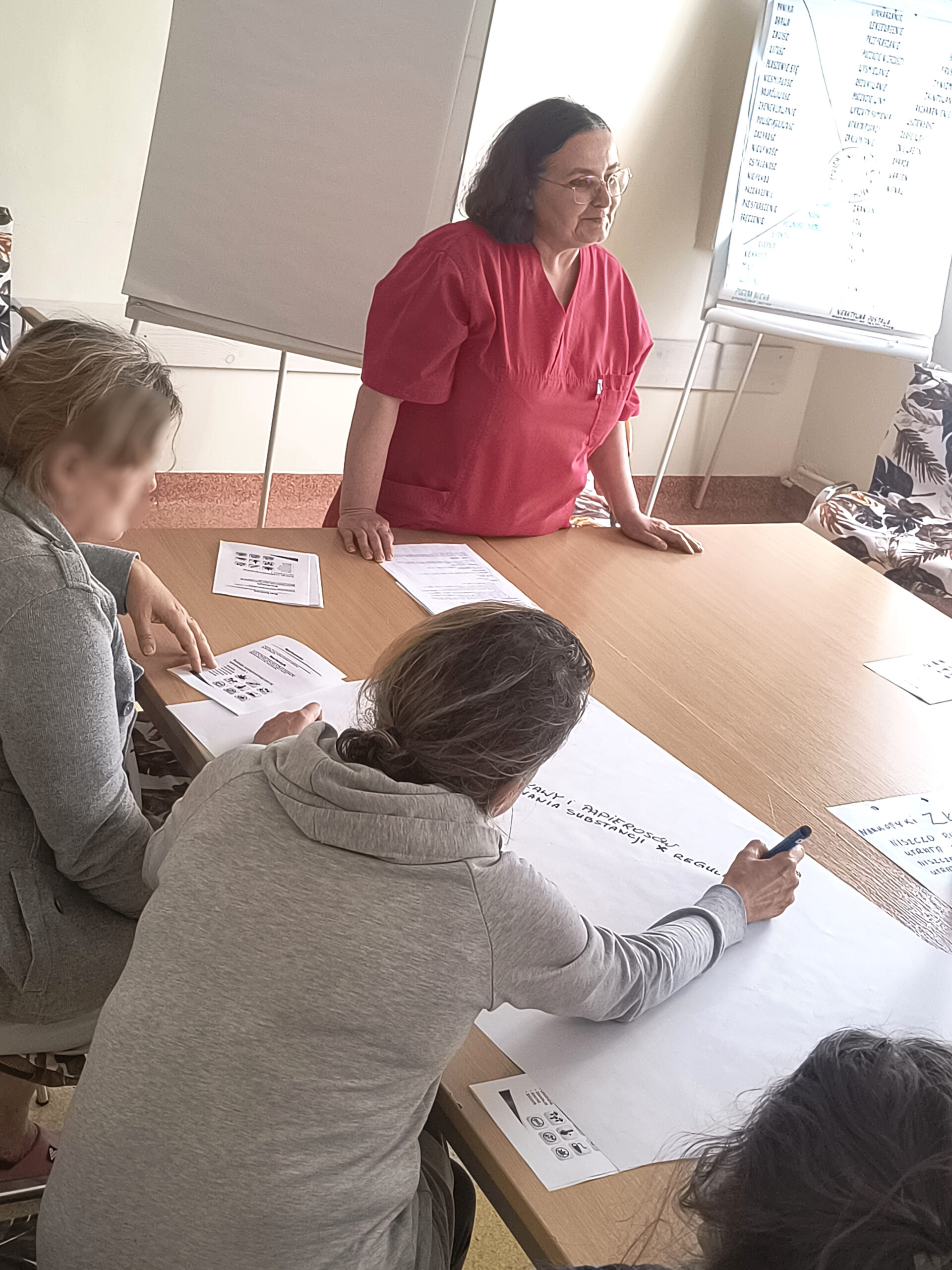 Grupa ludzi siedzi w salce na zajęciach jest widno Słuchają wykładu
