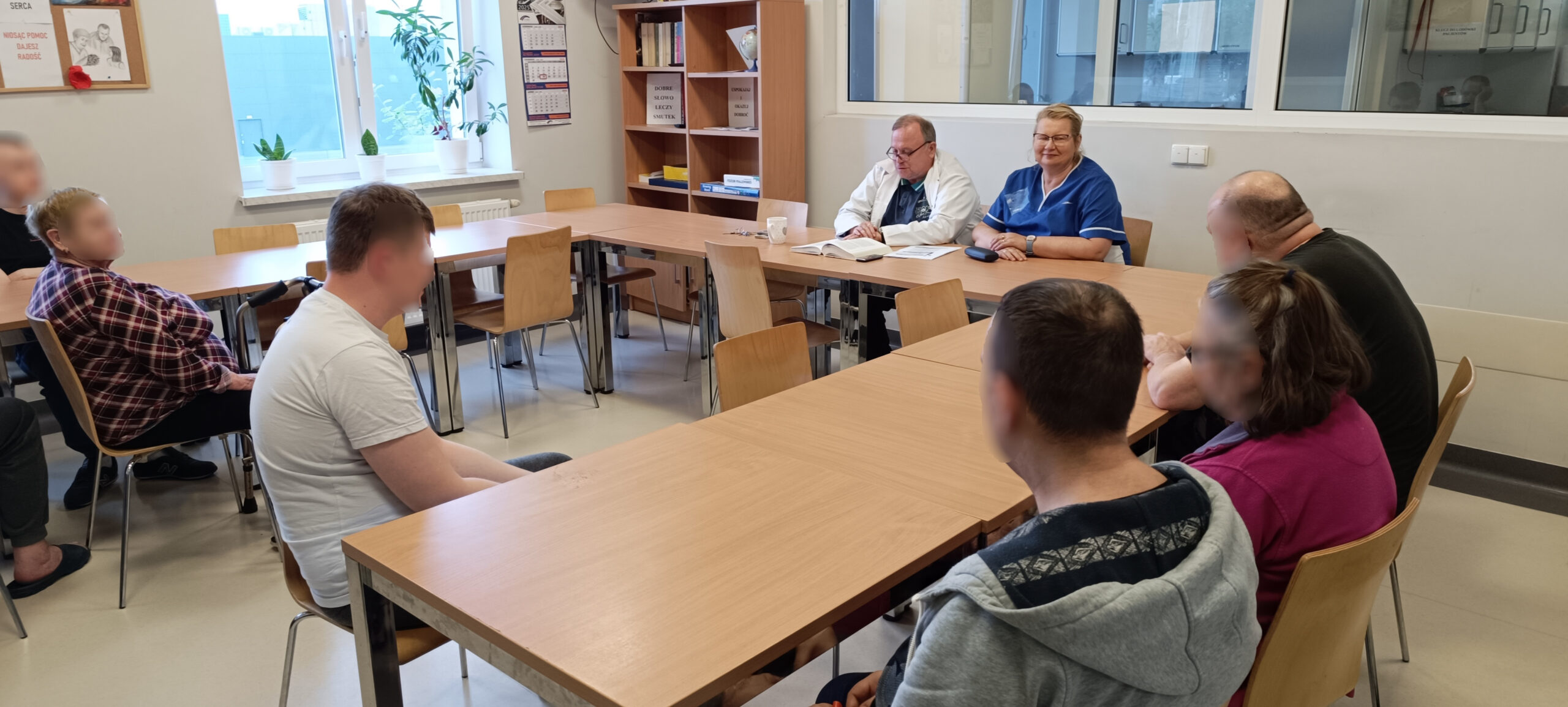Grupa ludzi siedzi w salce na zajęciach jest widno Słuchają wykładu