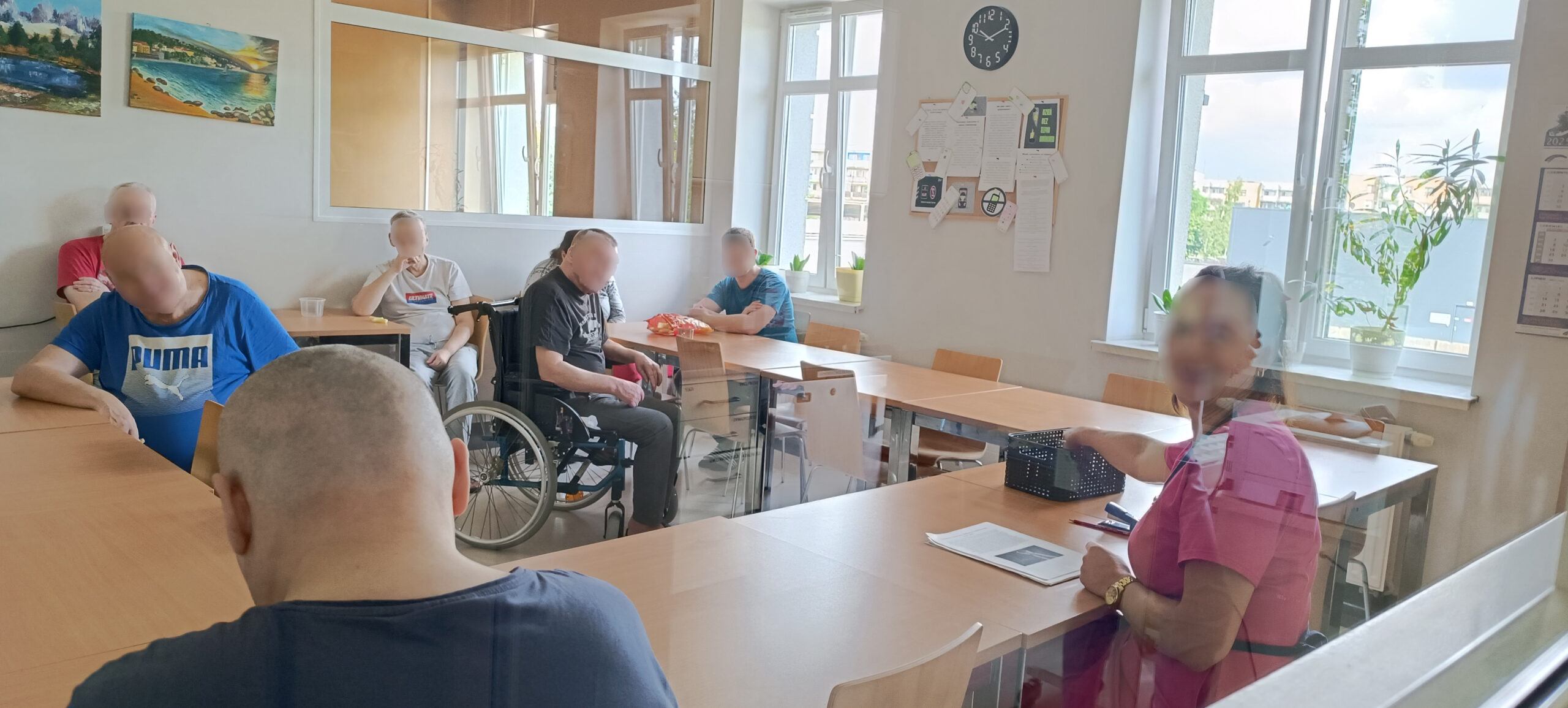 Zajęcia na sali. Kilku mężczyzn słucha jak kobieta opowiada
