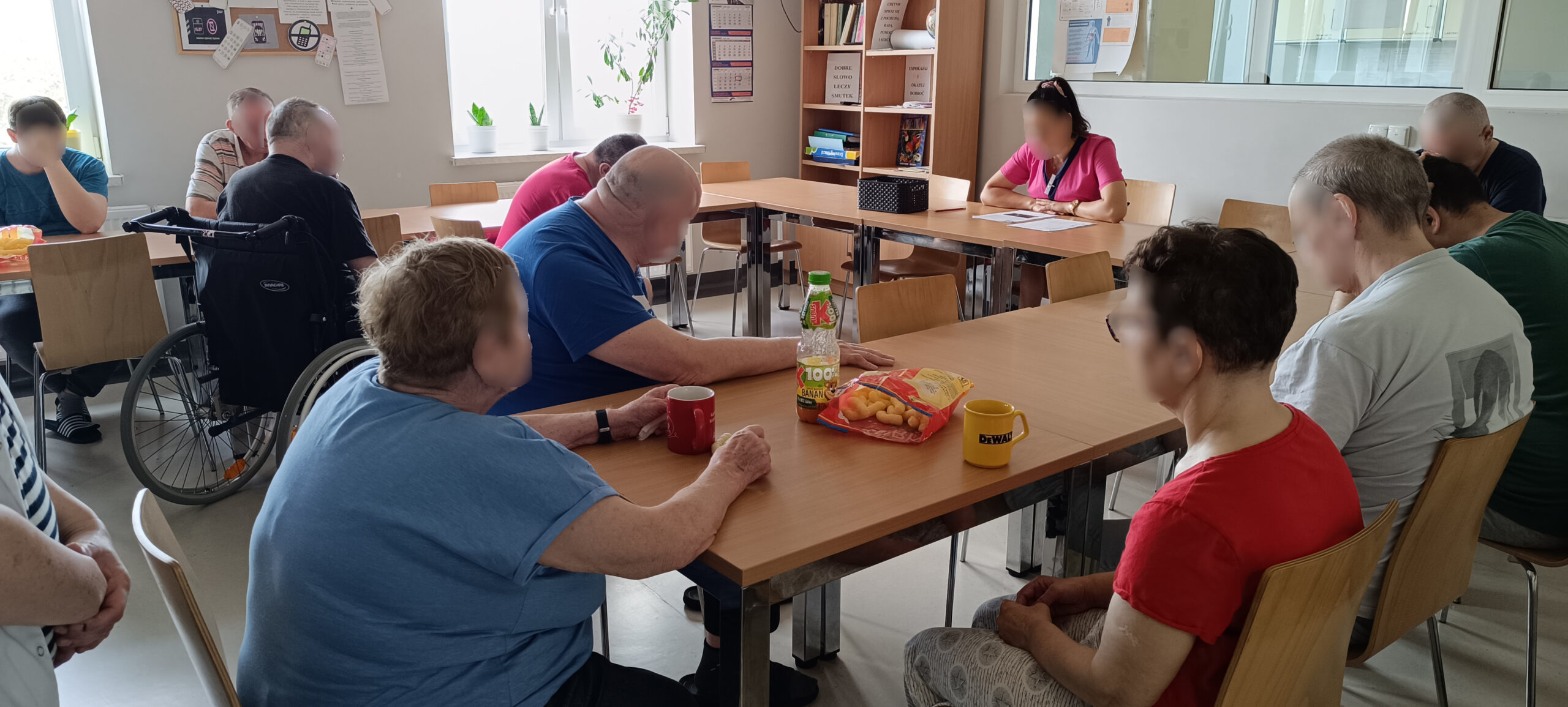 Zajęcia na sali. Kilku mężczyzn słucha jak kobieta opowiada
