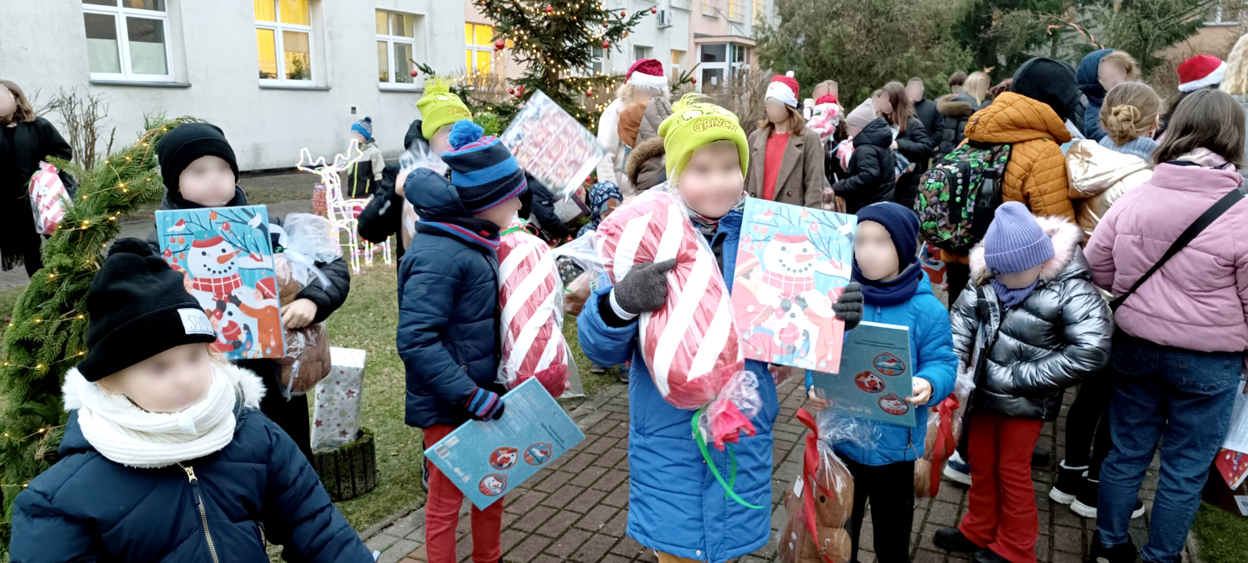 Impreza Mikołajkowa w szpitalnym, ogrodzie na podwórku pełnym dzieci, choinka rozdawanie prezentów, warsztaty