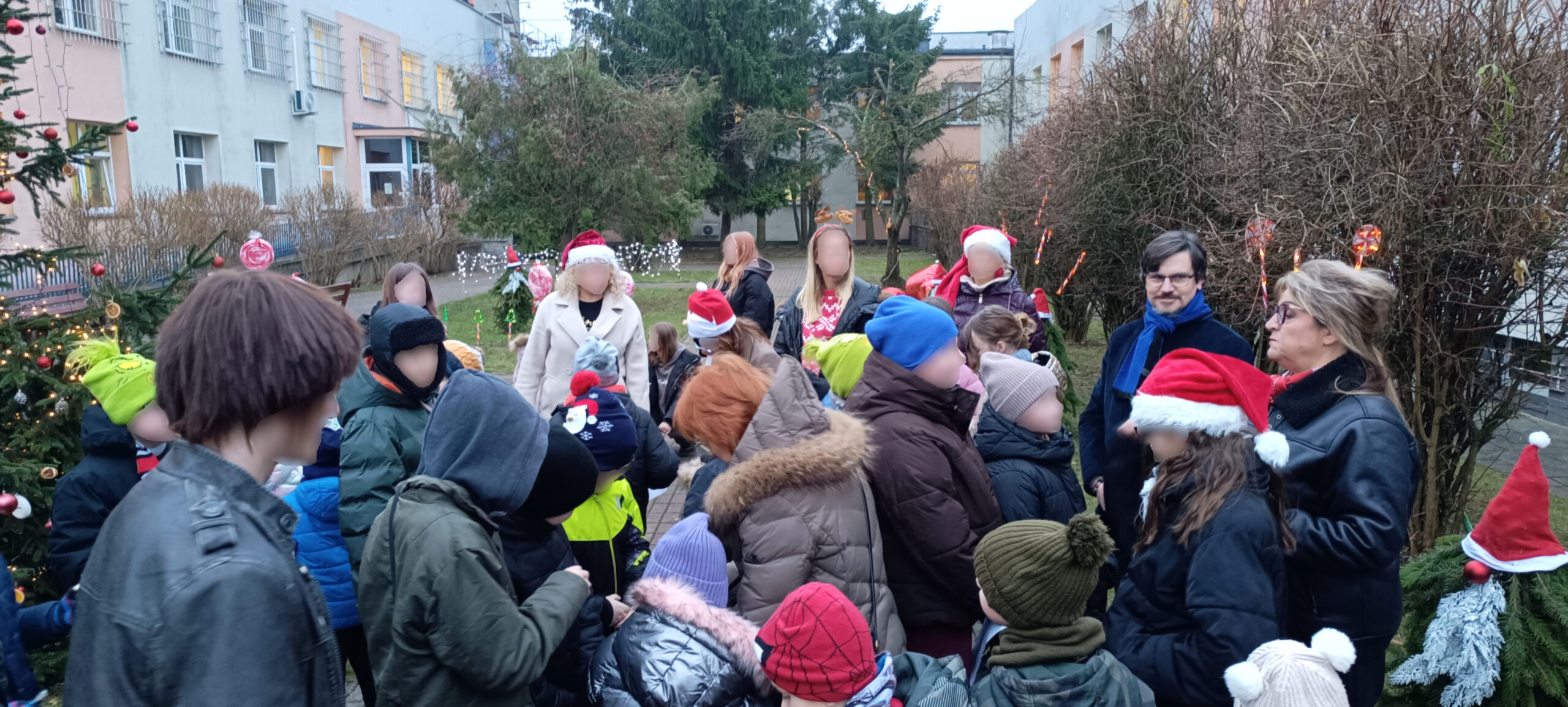 Impreza Mikołajkowa w szpitalnym, ogrodzie na podwórku pełnym dzieci, choinka rozdawanie prezentów, warsztaty