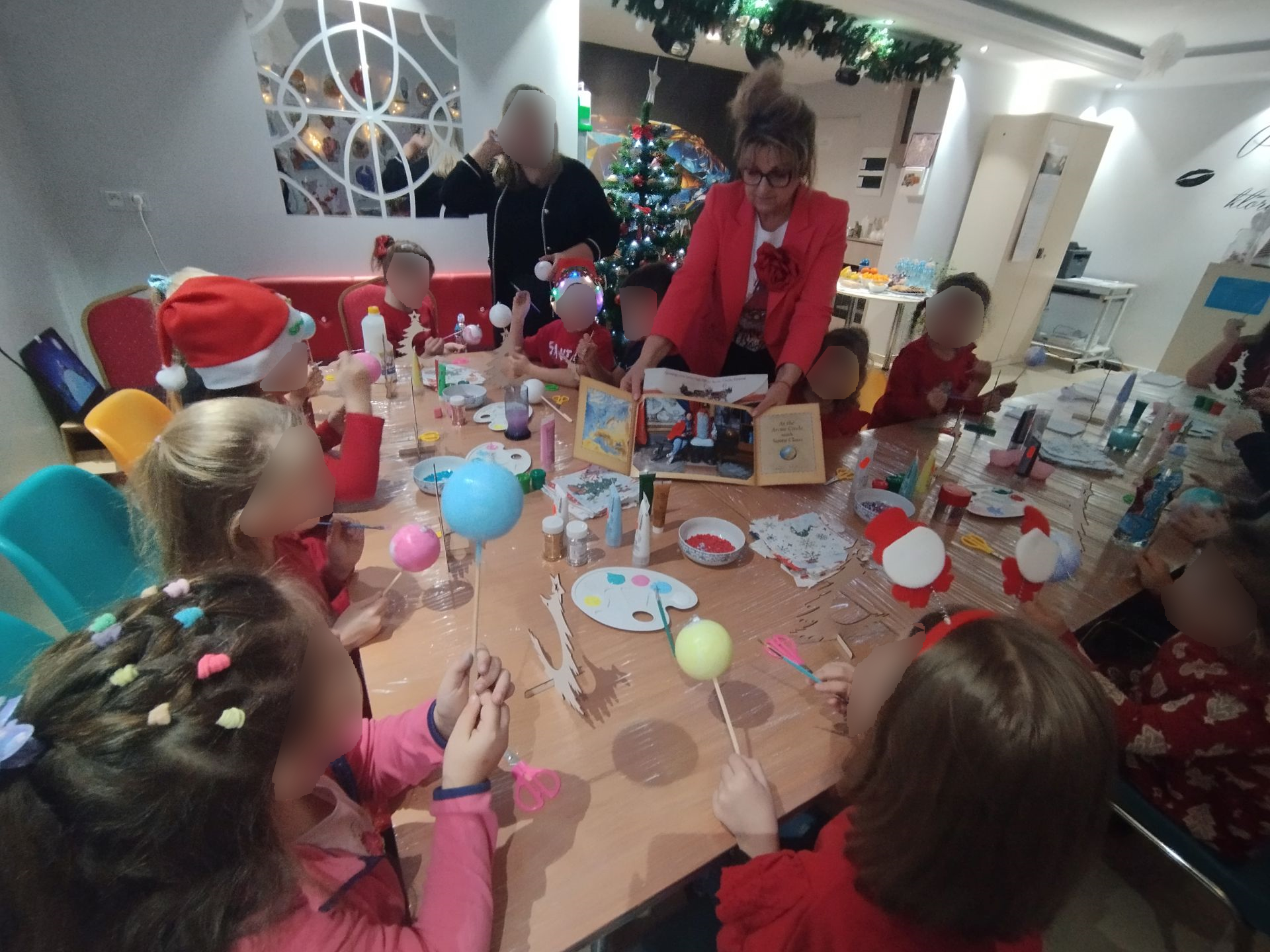 Impreza Mikołajkowa na sali pełnej dzieci, choinka rozdawanie prezentów, warsztaty