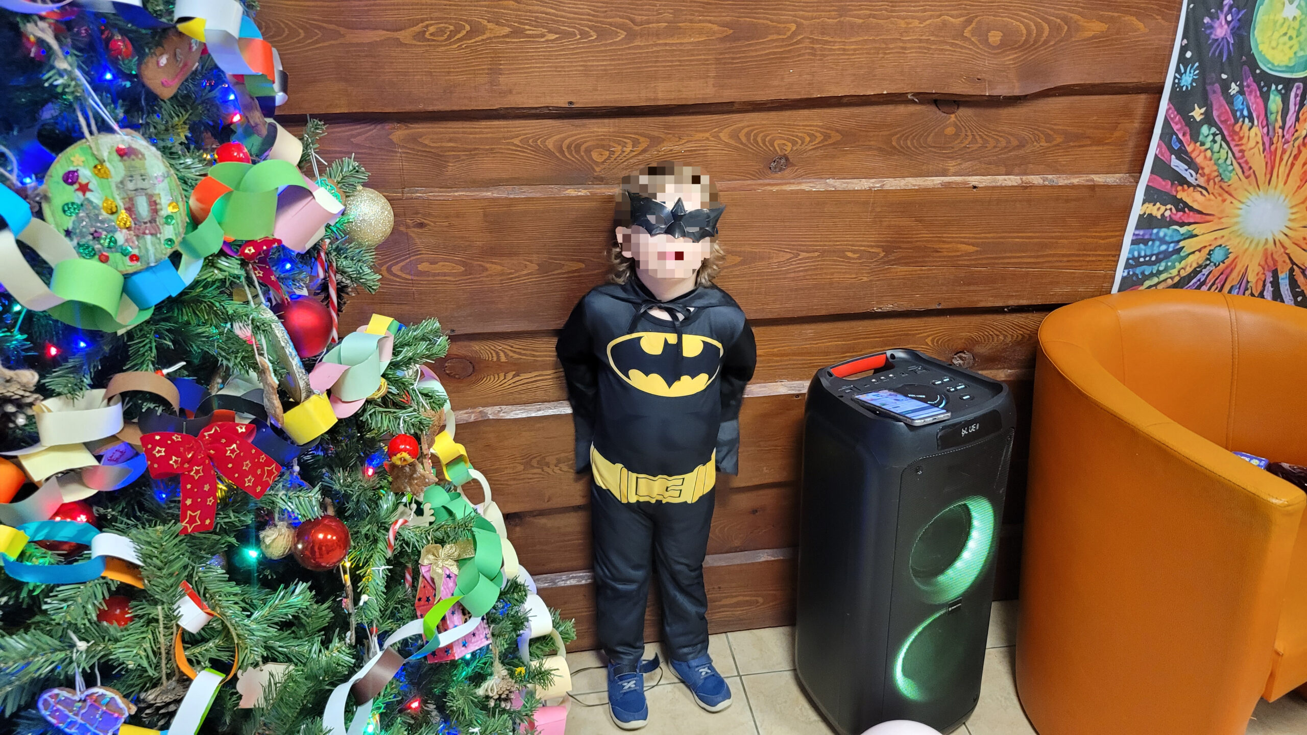 Chłopiec przebrany za batmana na zabawie karnawałowej w swiątecznej atmosferze