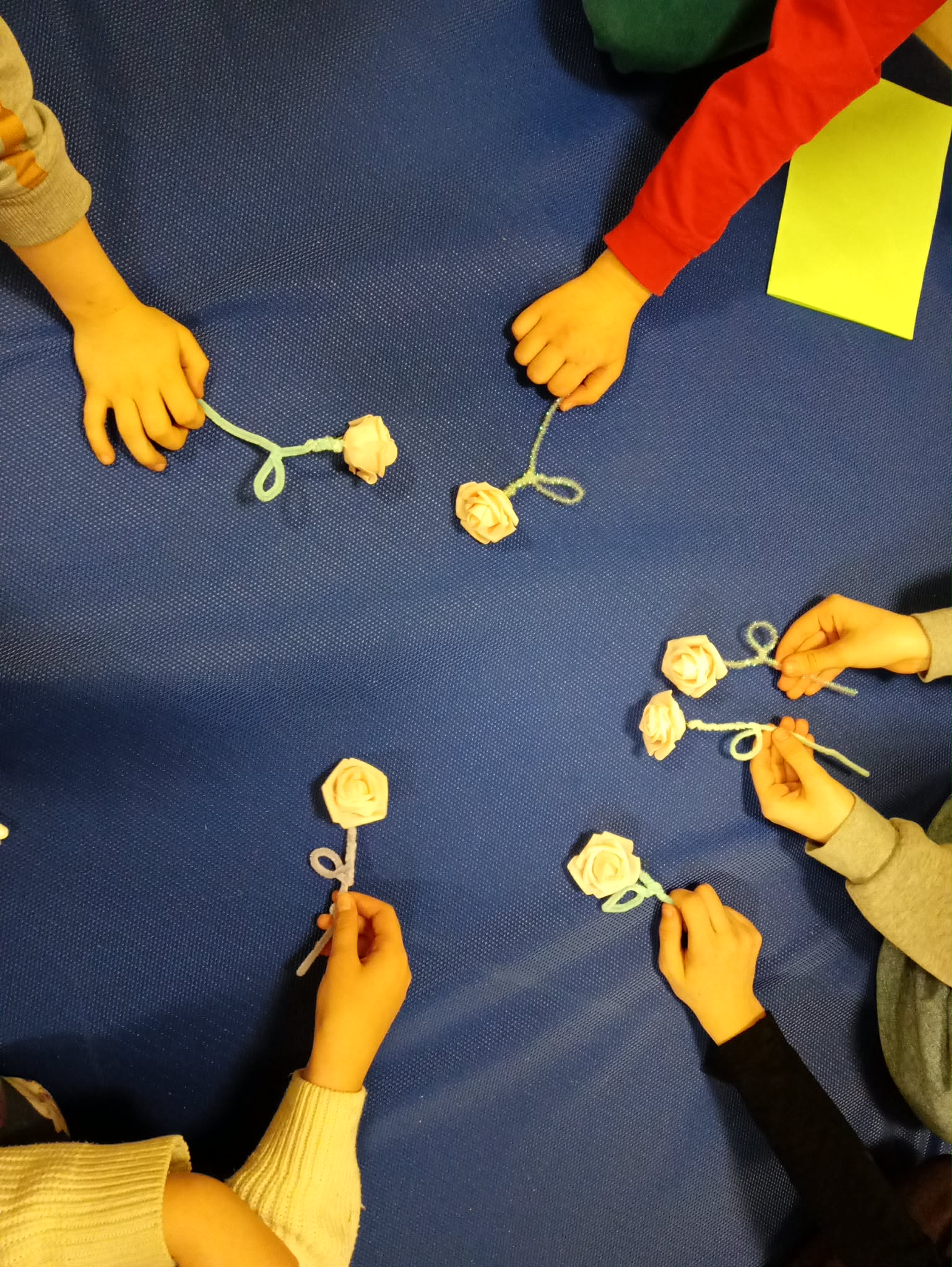 kilka par rąk trzyma własnoręcznie zrobione kwiatki