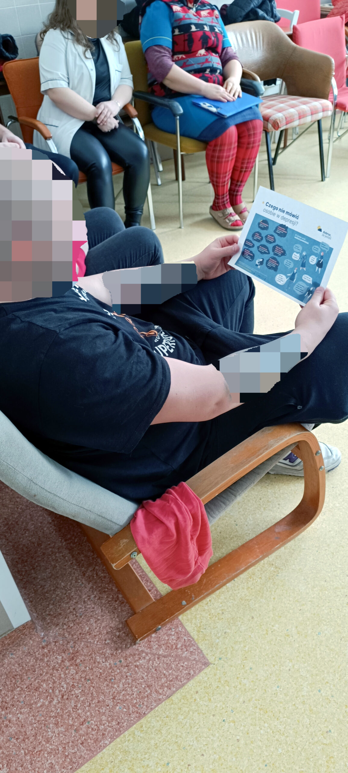 Młody Mężczyzna na sali podczas wykładu spogląda na materiały reklamowe związane z depresją