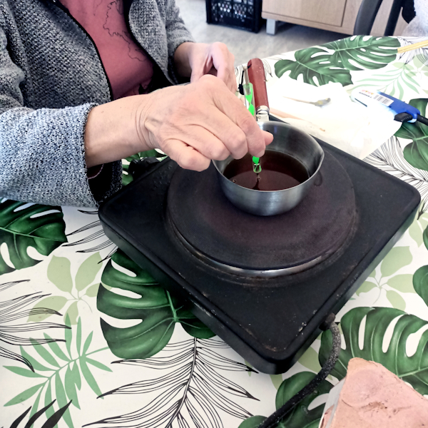 Warsztaty malowania jajek świątecznych. Kobieta oraz mężczyzna na stoliku wykonuje malowanie jajka tradycyjną metodą