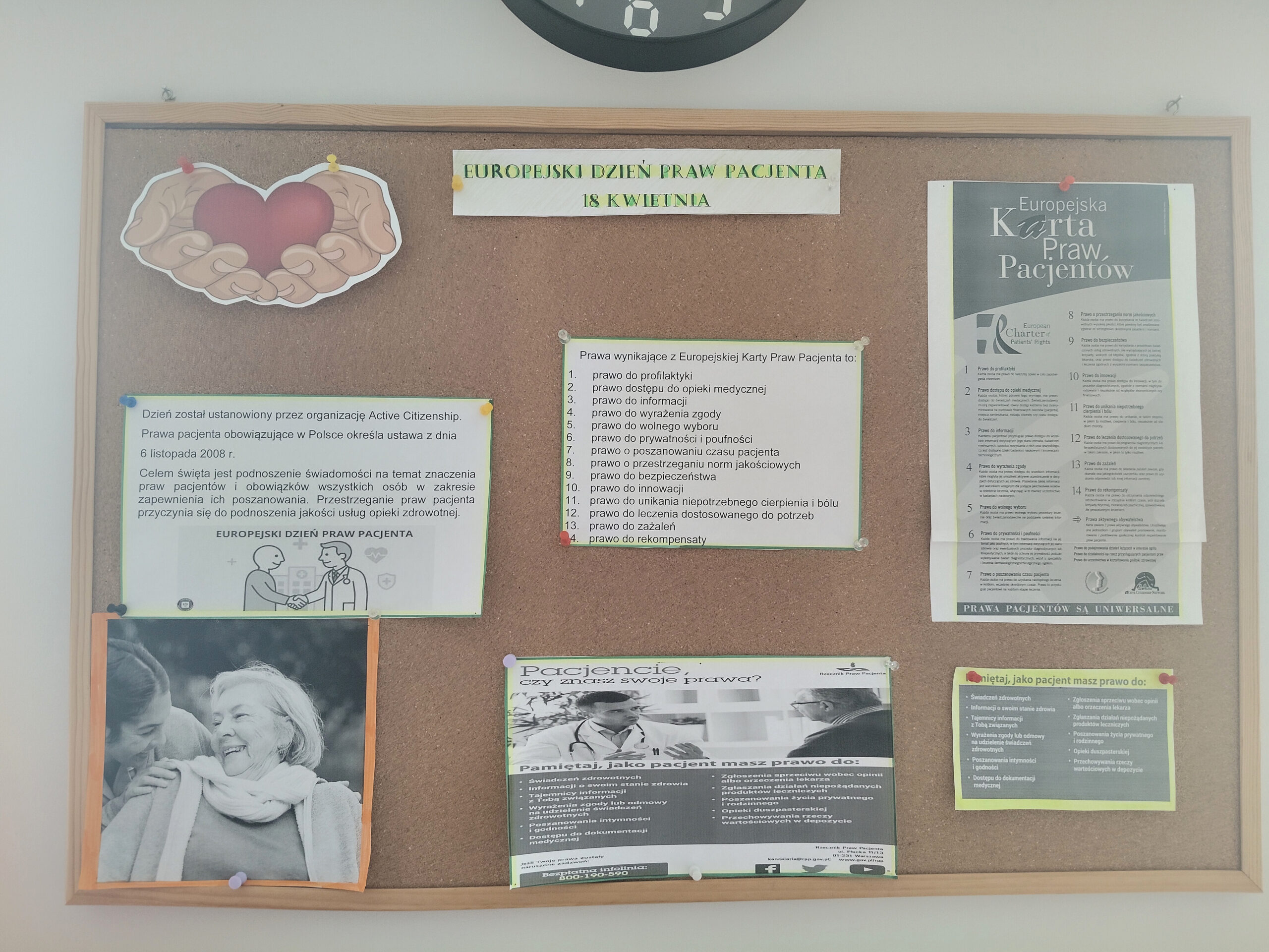 Tablica korkowa na holu  wisząca pod zegarem. Na tablicy informacje dotyczące praw pacjenta