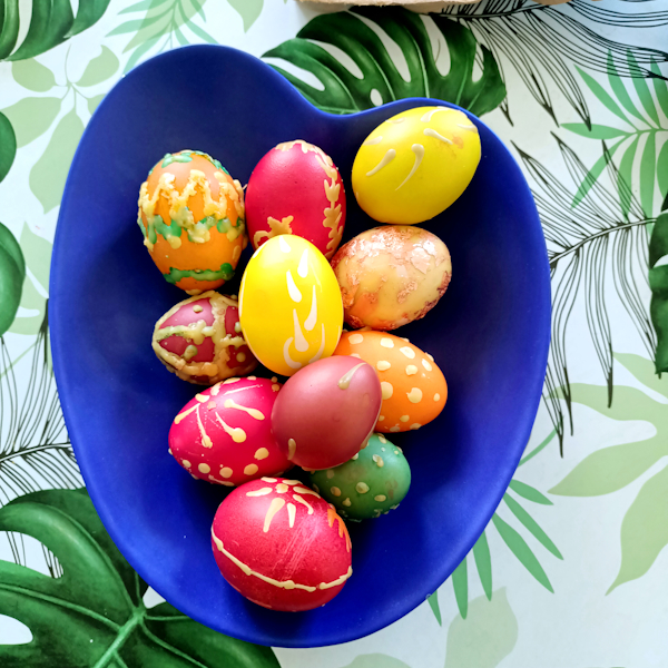 Warsztaty malowania jajek świątecznych. Kobieta oraz mężczyzna na stoliku wykonuje malowanie jajka tradycyjną metodą